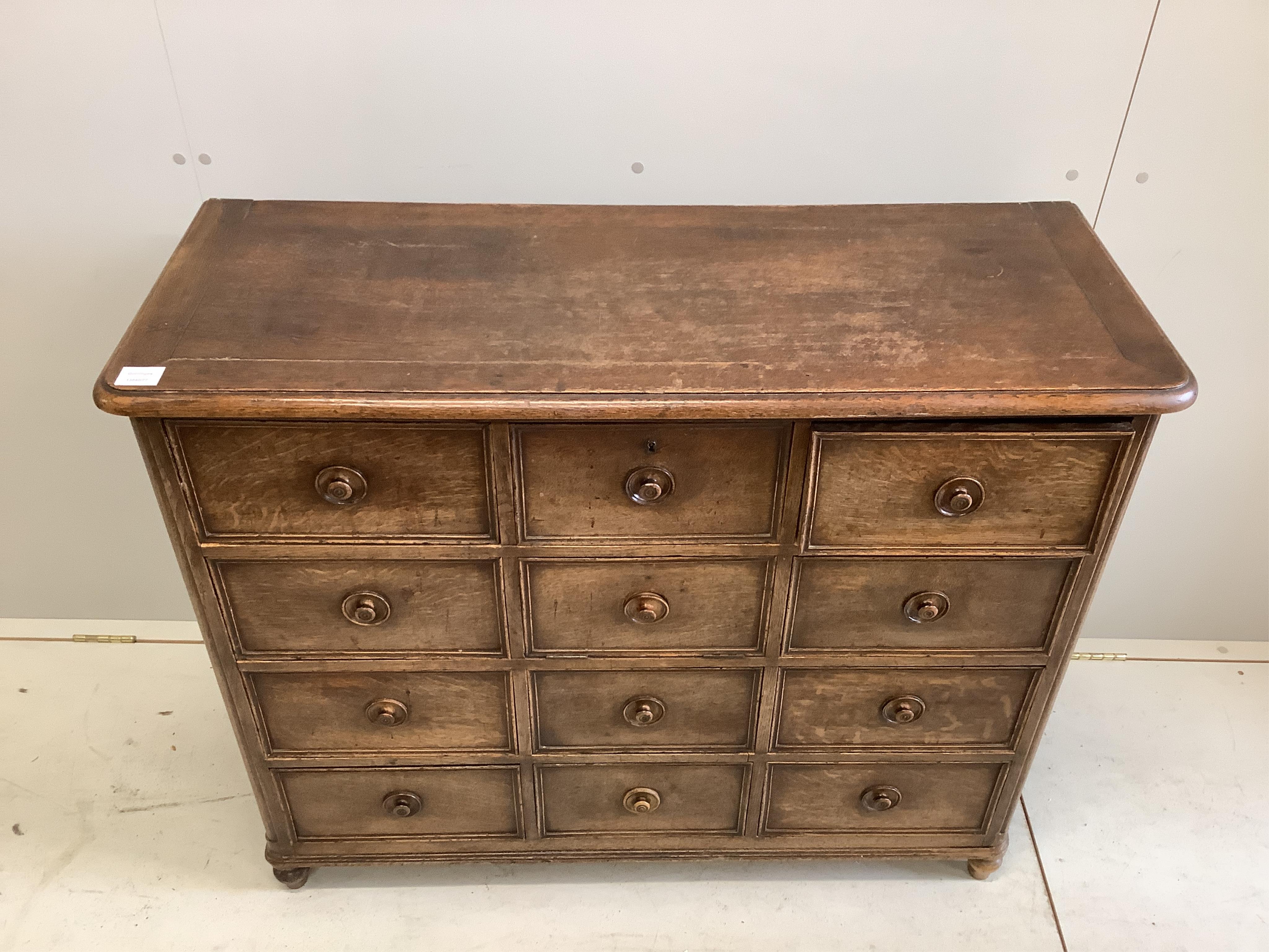 A 19th century French oak chest with central fall front door surrounded by eleven short drawers, width 110cm, height 91cm. Condition - fair to good